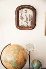 Vintage shabby mirror with an arched dark brown frame and heavily flaking surface.