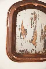 Shabby distressed mirror surface with flaking silver and chipped brown frame.