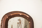 Arched, distressed brown frame with chippy paint on the vintage shabby mirror.