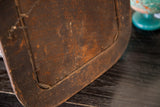 Distressed dark wood back panel and frame construction of the vintage shabby mirror.