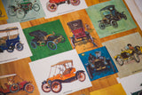 Angled detail of the vintage poster's colorful illustrations of antique cars.