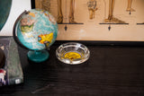 Vintage Sands Hotel ashtray, clear glass with bright yellow logo, angled view.