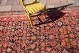 Vintage Hamadan runner's charcoal field with geometric Herati design and red-orange border.