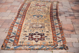 Geometric patterns in madder red, teal, and gold on an antique Karaja runner segment.