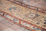 Antique Karaja runner detail showing geometric patterns in teal, rust, and beige, with worn edge.