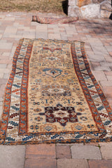 Elongated antique Northwest Persian runner displaying geometric motifs and time-softened colors.