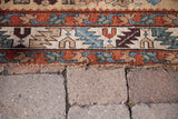 Antique Northwest Persian rug border detail: teal, rust, and beige geometric motifs with natural aged wear.