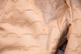 Ivory beige textured scalloped lining of vintage fur coat with small stain.