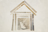 House-shaped collage of antique photo strips centered on a vintage photograph of a sitting cat.