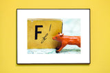F is for Fox vintage alphabet photograph with a miniature orange fox and alphabet book on a vintage map.