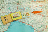 Miniature alphabet books and a tiny fox figurine spell FOX on a vintage map of Italy.