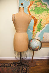 Vintage Dress Form with worn wire cage base and ornate dark metal stand.