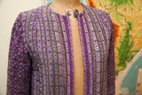 Andre Laug robe with a vivid purple and cream striped floral pattern.