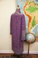 Full back view of purple Andre Laug coat, intricate floral pattern and banded trim.