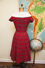 Back view of vintage 50s red plaid dress, showing metal zipper and pleated skirt.