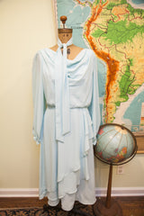 Vintage 70s pale blue chiffon dress with draped neckline, long sleeves, and necktie.
