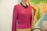 Close-up of the vintage raspberry pink knit sweater's textured back and ribbed hem.