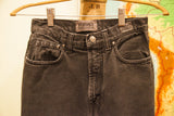 Close-up of vintage Versace faded black acid wash denim fly and button.