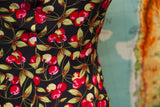 Fitted side of Betsey Johnson dress, showcasing its iconic red cherry and leaf pattern.