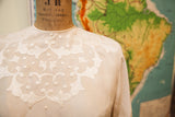 Delicate white scroll and dot embroidery on ivory pink vintage silk blouse.