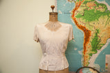 Vintage 1940s sculptured rayon blouse in cream with intricate sheer embroidered neckline.