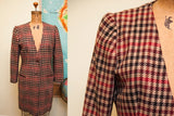 Red, black, and tan houndstooth texture on the Armani blazer's shoulder.