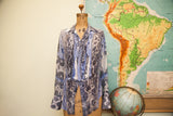 Intricate blue and dark pattern on the pleated front of a vintage Gaultier silk blouse.