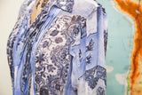Vintage Gaultier silk blouse with pleated front, showing blue patterns and religious imagery.