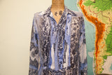 Pleated front detail of the blue and black silk blouse with religious imagery.