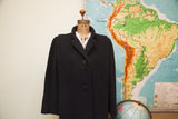 Vintage Trigere black wool coat with sculpted shoulders, sized L/XL.