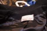 White designer label and black satin lining of a vintage Trigere coat.