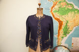 Vintage Linda Hutley navy blue cardigan with ornate patterned trim and gold buttons.