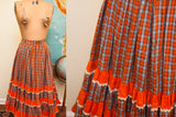 Tiered orange ruffles with white lace trim on a vintage plaid skirt.