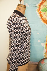 Side view of knit cardigan, brown and white geometric squares with rectangular inserts.