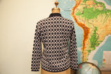 Geometric black and white pattern on the back of the knit cardigan sweater.