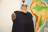 Vintage 60s black romper dress with draped neckline, shoulder bow, and vertical pleats.
