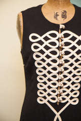 Close-up of the intricate white piping and silver button details on the vintage Moschino dress.