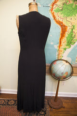 Back view of the vintage Moschino black dress showing its long, sleeveless silhouette.