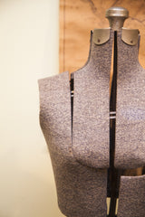Detail of mottled grey fabric texture and adjustable panels on the mid-century dress form.