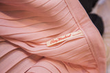 Patty Woodard brand label on vintage pink pleated dress fabric.