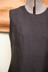 Textured silk fabric and tailored dart seam on the sleeveless bodice of a vintage dress.