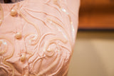Pink taffeta vintage dress with swirling sequin detailing and two round buttons.