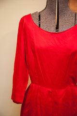 The scoop neckline and smooth, satin-like bodice of the vintage red dress.