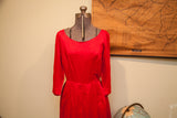 Vintage 50s red dress highlighting its scoop neckline and low waist.