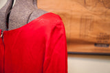 Gathered shoulder and zipper detail on a lustrous vintage red dress.