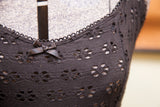 Black Betsey Johnson dress with floral cut-outs, scalloped neckline, and small bow.