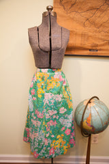 Vintage Herman Geist floral skirt with vibrant green, pink, yellow pattern and side buttons.