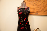 Square neckline and bold red floral pattern on the vintage black velvet dress.