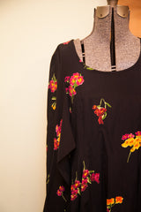 Vibrant pink, yellow, and red floral print on the black Betsey Johnson dress shoulder.