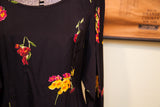 Vintage Betsey Johnson black dress fabric with vivid red, yellow, and pink floral motif.